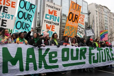 Getty Images Protesters hold a banner that reads "Make our Future"