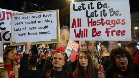 Getty Images Pro-hostage deal demonstrators hold signs in a demonstration saying 'the deal could have been sealed on May, lots of lives could have been saved' and 'let it be, let it be, all hostages will be free'.