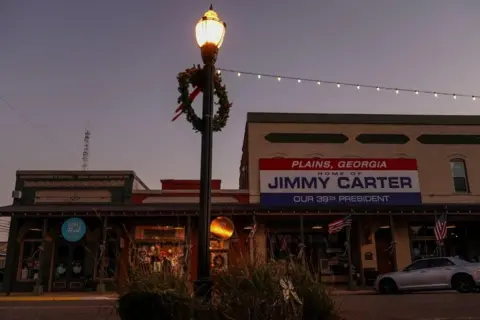 Reuters A sign that reads "Plans, Georgia Home of Jimmy Carter Our 39th President" hangs outside a shop