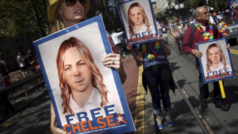 FILE PHOTO -- People hold signs calling for the release of imprisoned wikileaks whistleblower Chelsea Manning while marching in a gay pride parade in San Francisco, California