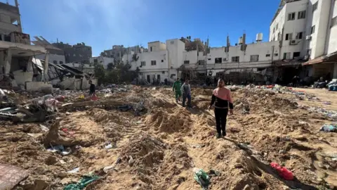 Reuters Palestinians inspect damages following an Israeli raid at Kamal Adwan hospital, in the northern Gaza Strip