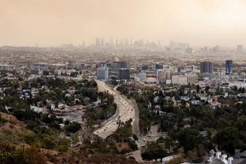 Carlin Stiehl/Reuters Heavy smoke fills the LA skyline as multiple fires rage in Los Angeles on Wednesday.