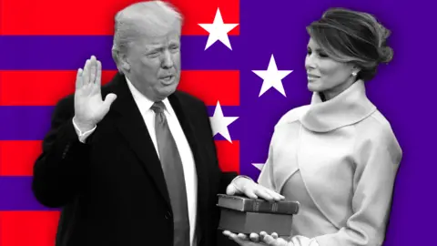 BBC Donald Trump, dressed in a suit and tie, places his hand on a Bible his wife Melania Trump is holding. They are standing before a background of red stripes and white stars on a purple background