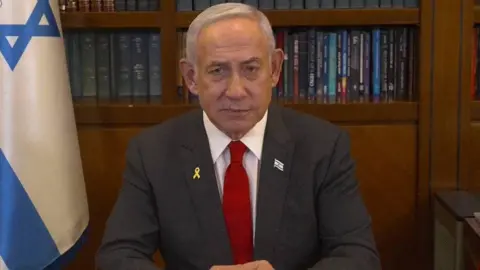 Israeli PM's office Netanyahu looks at the screen as he addresses the Israeli nation.