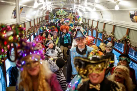 Eduardo Munoz / REUTERS Revellers wearing fancy dress, masks and wigs inside a streetcar as part of a parade in New Orleans