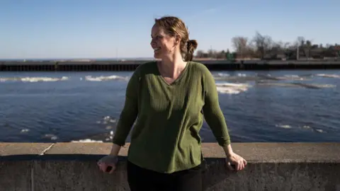 Getty Images Christina Welch wears a green sweater while standing near the water in Duluth