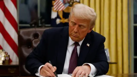 Getty Images Donald Trump signing a document in Oval Office