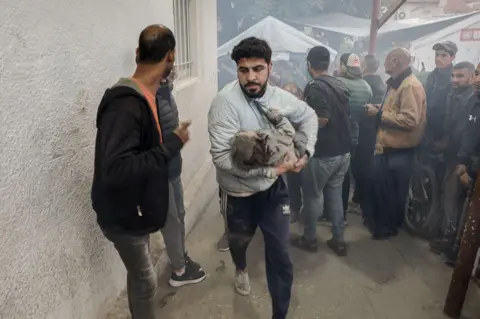 AFP Rescue worker Nooh Al-Shagnobi rushes an injured child into the Al-Ahli Baptist Hospital in Gaza City. 